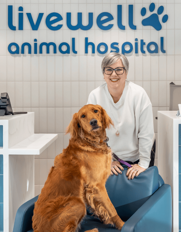 Hospital manager Jenn Plautz smiling by dog